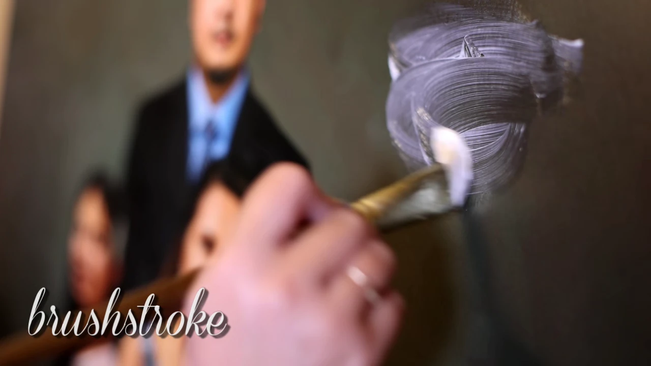 A brush working physical texture across a printed portrait canvas