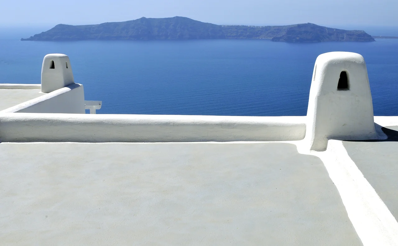 A roof terrace in Imerovigli looking across Santorini’s caldera toward Therasia